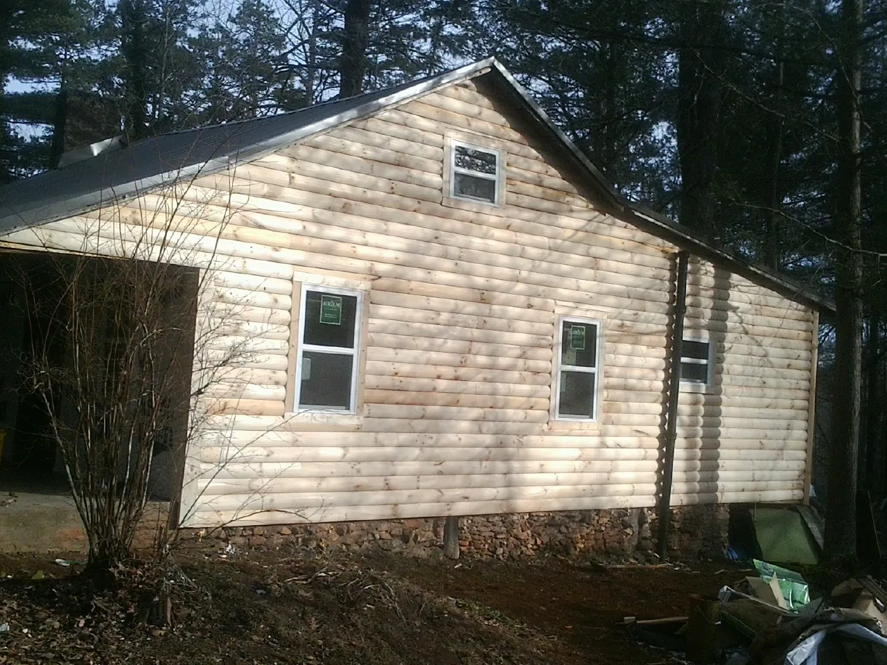 New log siding and dark metal roofing on a gable end in Silver Gate