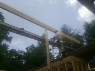 Carpenter setting a ridge beam over a new addition frame — Ice Dam Removal by Roofing Brothers in Silver Gate