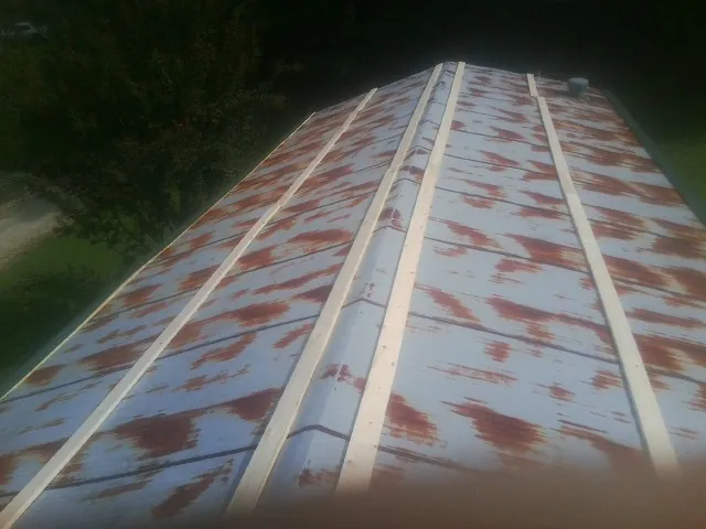 Rusted metal roof panels with new wood purlins before replacement — Storm Damage Roof Repair in Silver Gate by Roofing Brothers