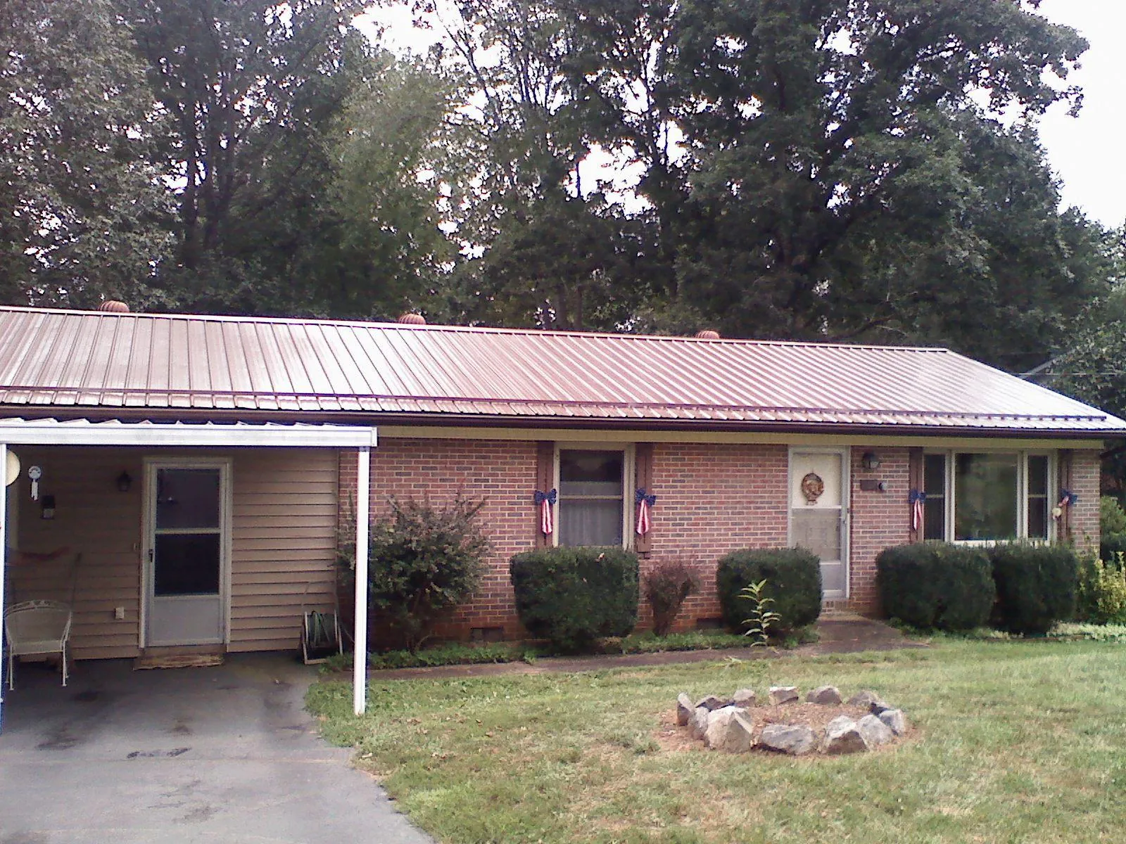 Bronze metal roof and carport on a brick ranch home — Roof Repair work by our crew in Silver Gate